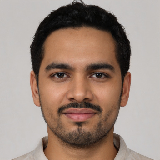 Joyful latino young-adult male with short  black hair and brown eyes