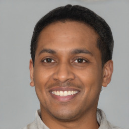 Joyful latino young-adult male with short  brown hair and brown eyes