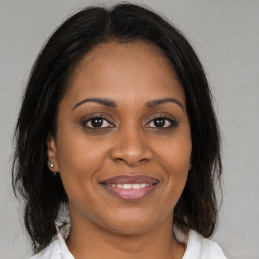 Joyful black young-adult female with medium  brown hair and brown eyes