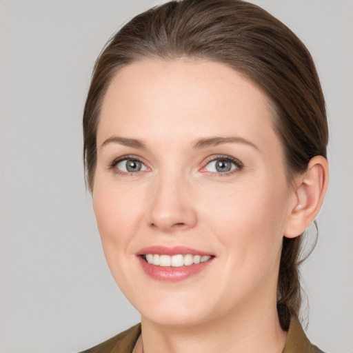 Joyful white young-adult female with medium  brown hair and grey eyes