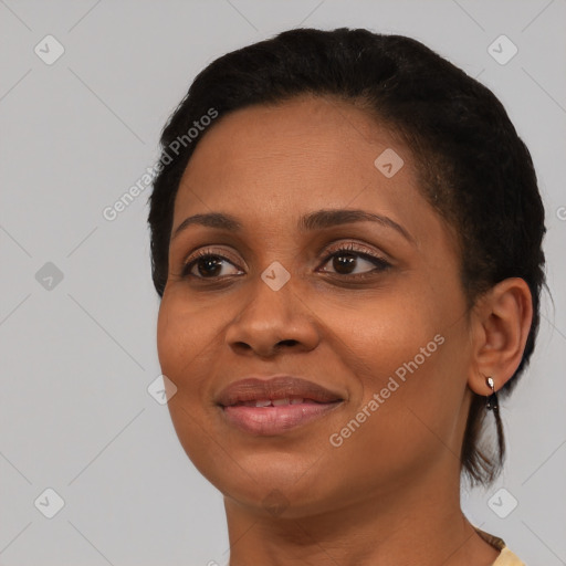 Joyful black young-adult female with short  black hair and brown eyes