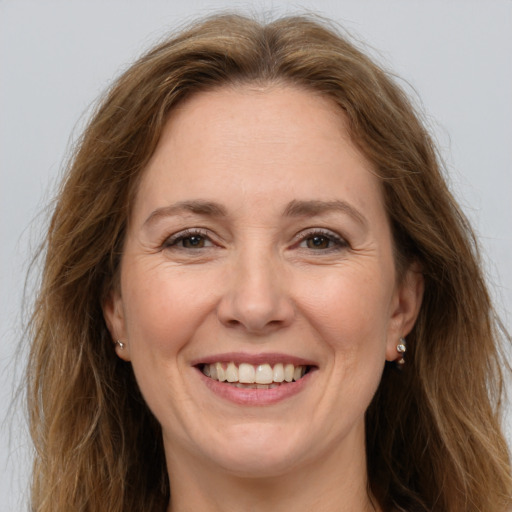 Joyful white adult female with long  brown hair and grey eyes