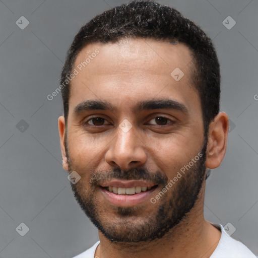 Joyful black young-adult male with short  black hair and brown eyes