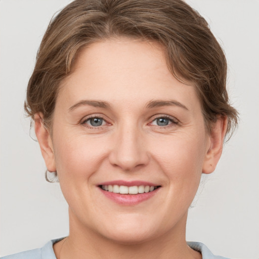 Joyful white young-adult female with short  brown hair and grey eyes