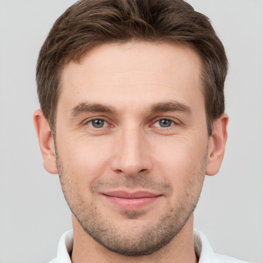 Joyful white young-adult male with short  brown hair and grey eyes