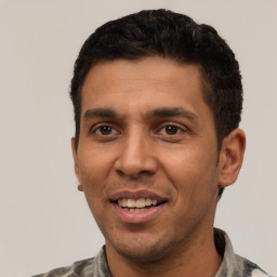 Joyful latino young-adult male with short  black hair and brown eyes