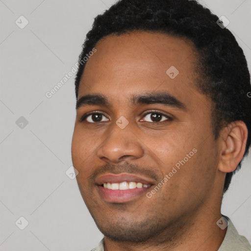 Joyful black young-adult male with short  black hair and brown eyes