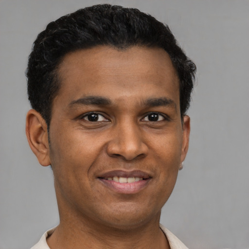 Joyful latino young-adult male with short  brown hair and brown eyes