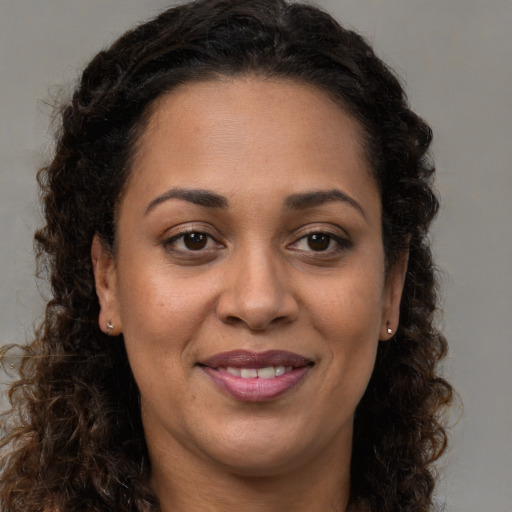 Joyful latino adult female with long  brown hair and brown eyes