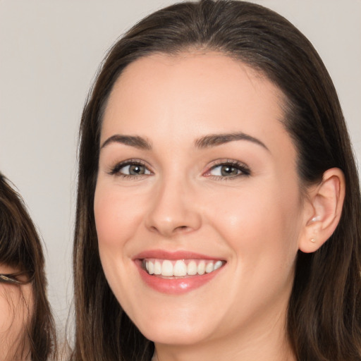 Joyful white young-adult female with long  brown hair and brown eyes