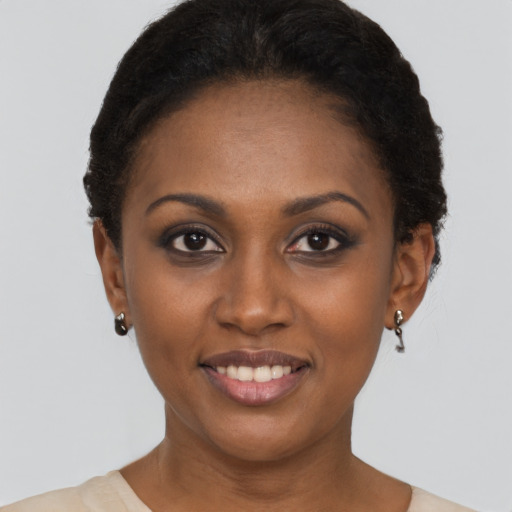 Joyful black young-adult female with short  black hair and brown eyes