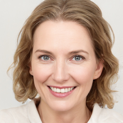 Joyful white young-adult female with medium  brown hair and blue eyes