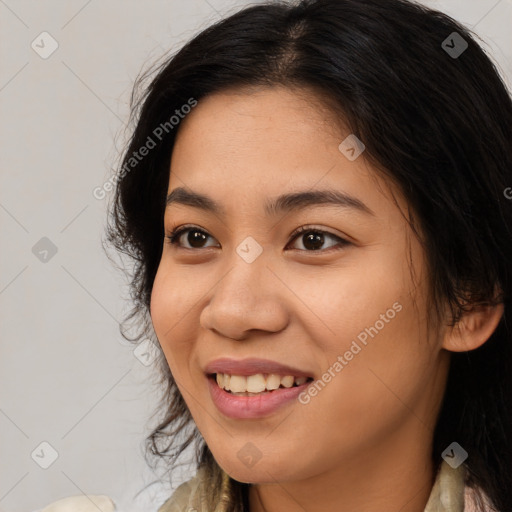 Joyful latino young-adult female with long  brown hair and brown eyes