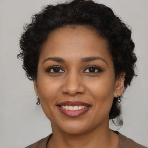 Joyful black young-adult female with short  brown hair and brown eyes