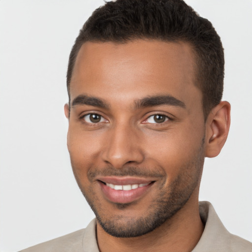 Joyful black young-adult male with short  brown hair and brown eyes