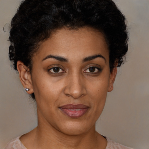 Joyful black young-adult female with short  black hair and brown eyes