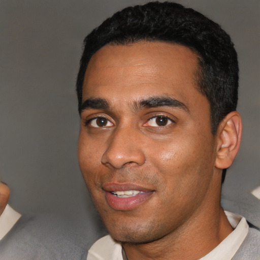 Joyful black young-adult male with short  black hair and brown eyes