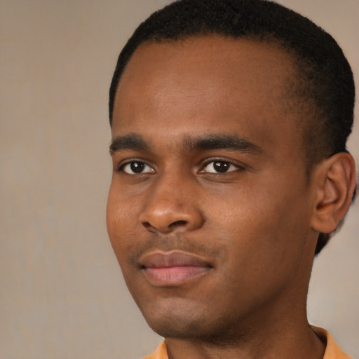 Joyful black young-adult male with short  brown hair and brown eyes