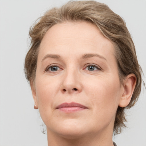 Joyful white adult female with medium  brown hair and grey eyes