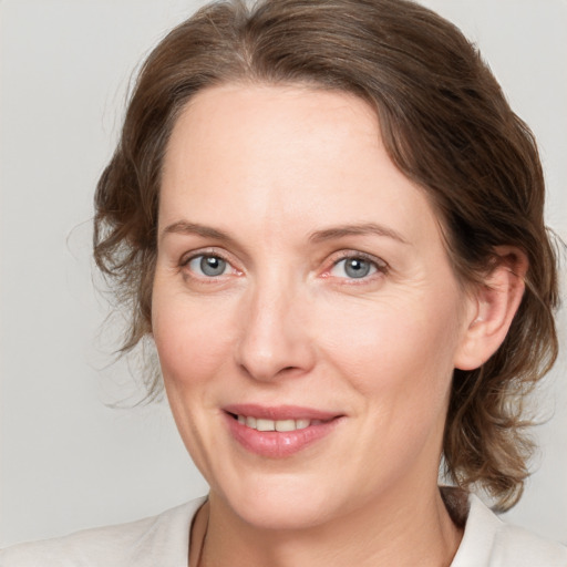 Joyful white adult female with medium  brown hair and grey eyes