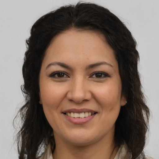Joyful latino young-adult female with long  brown hair and brown eyes