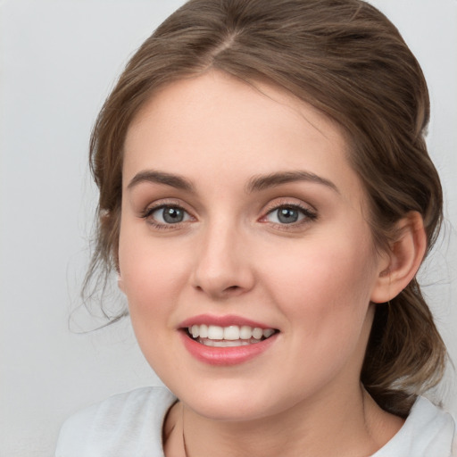 Joyful white young-adult female with medium  brown hair and blue eyes