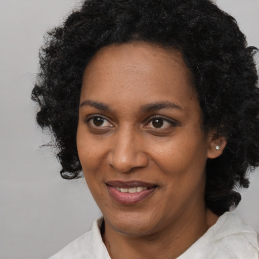Joyful black adult female with short  black hair and brown eyes