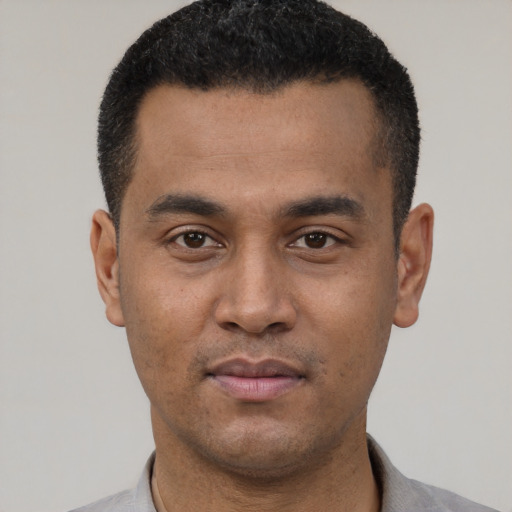 Joyful latino young-adult male with short  black hair and brown eyes