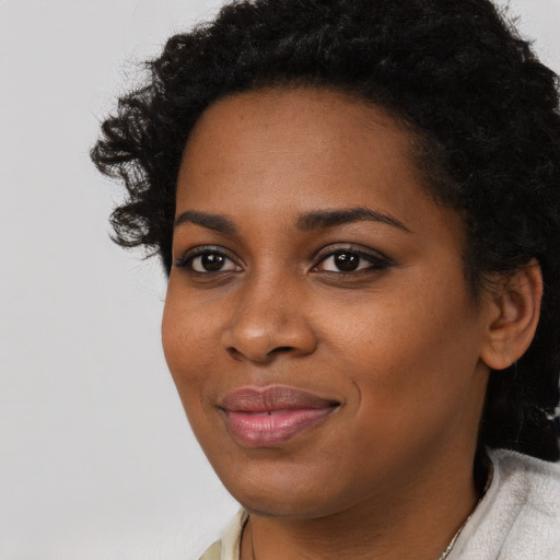 Joyful black young-adult female with short  black hair and brown eyes