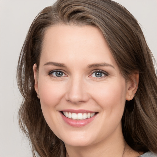 Joyful white young-adult female with medium  brown hair and grey eyes