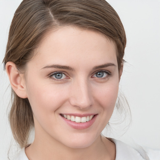 Joyful white young-adult female with medium  brown hair and blue eyes