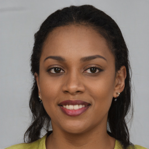 Joyful black young-adult female with long  brown hair and brown eyes