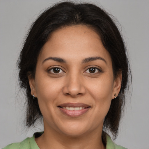 Joyful latino young-adult female with medium  brown hair and brown eyes