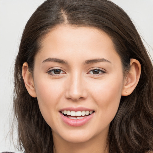 Joyful white young-adult female with long  brown hair and brown eyes