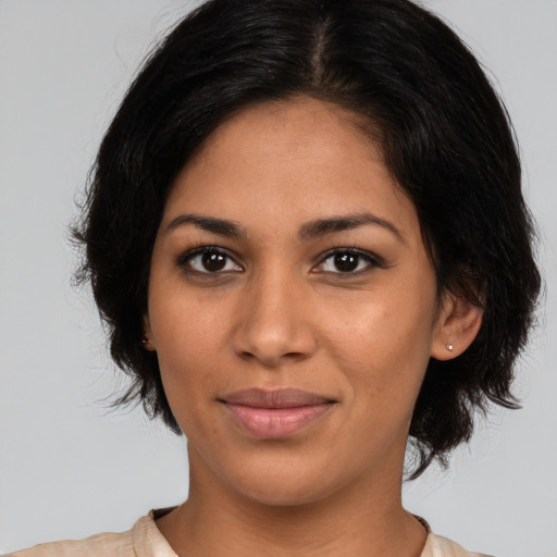 Joyful latino young-adult female with medium  brown hair and brown eyes