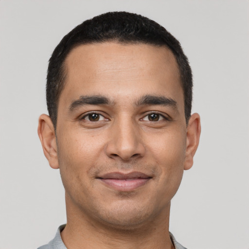 Joyful latino young-adult male with short  black hair and brown eyes