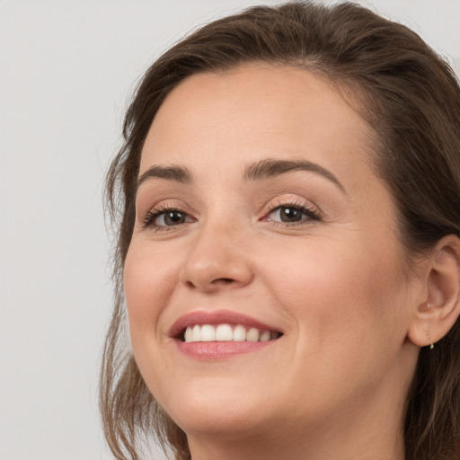 Joyful white young-adult female with long  brown hair and grey eyes