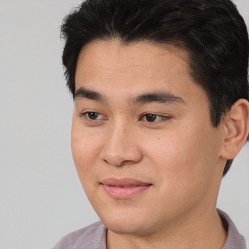 Joyful asian young-adult male with short  brown hair and brown eyes