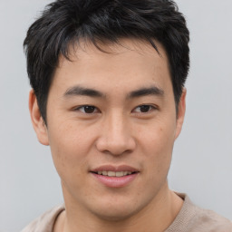 Joyful asian young-adult male with short  brown hair and brown eyes