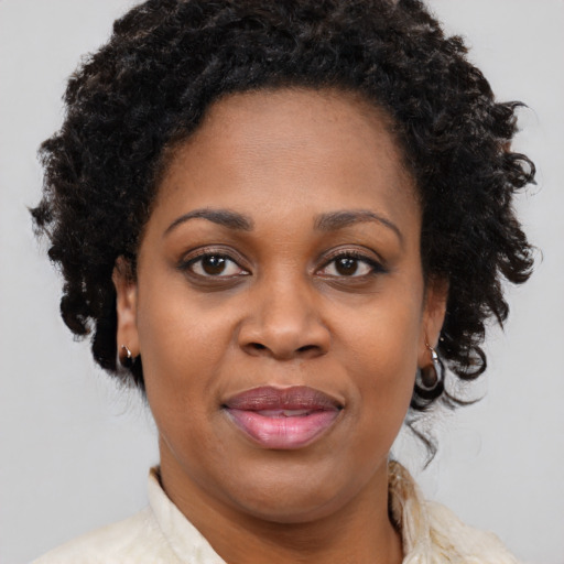 Joyful black adult female with medium  brown hair and brown eyes