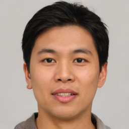 Joyful asian young-adult male with short  black hair and brown eyes