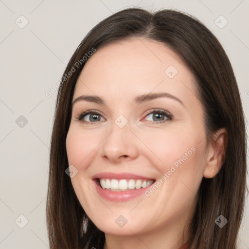 Joyful white young-adult female with long  brown hair and brown eyes