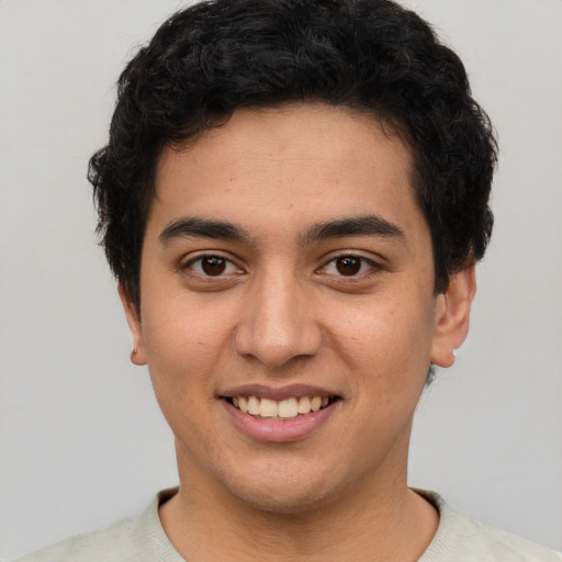 Joyful latino young-adult male with short  black hair and brown eyes