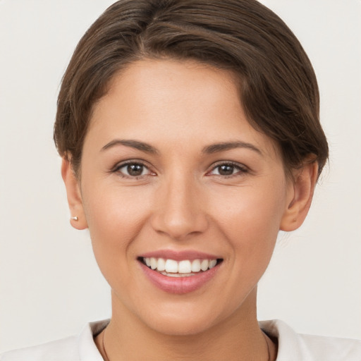 Joyful white young-adult female with short  brown hair and brown eyes