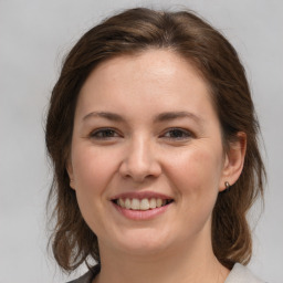 Joyful white young-adult female with medium  brown hair and grey eyes