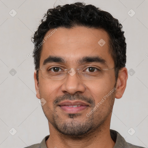 Joyful latino young-adult male with short  black hair and brown eyes