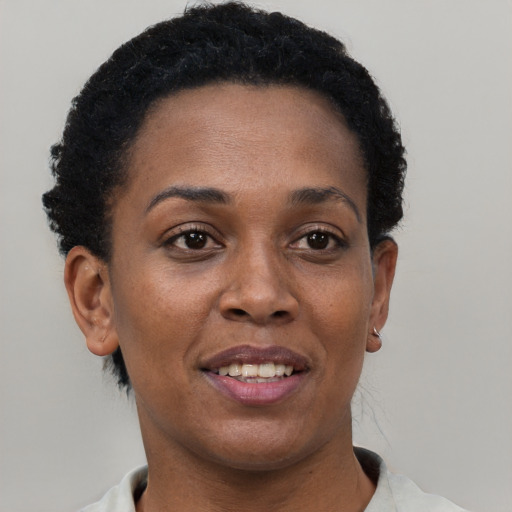 Joyful black adult female with short  brown hair and brown eyes