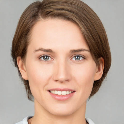 Joyful white young-adult female with medium  brown hair and grey eyes