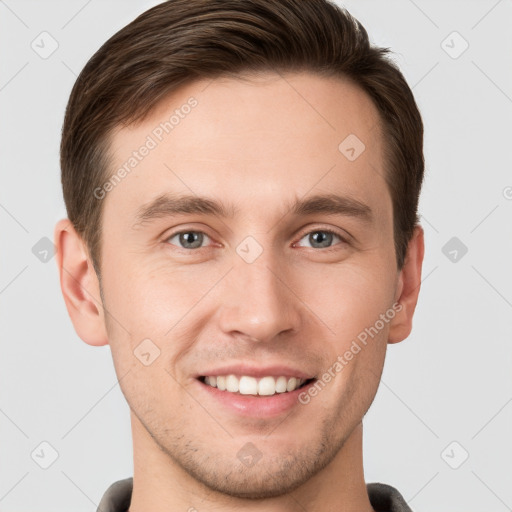 Joyful white young-adult male with short  brown hair and grey eyes