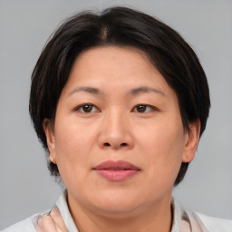 Joyful asian adult female with medium  brown hair and brown eyes